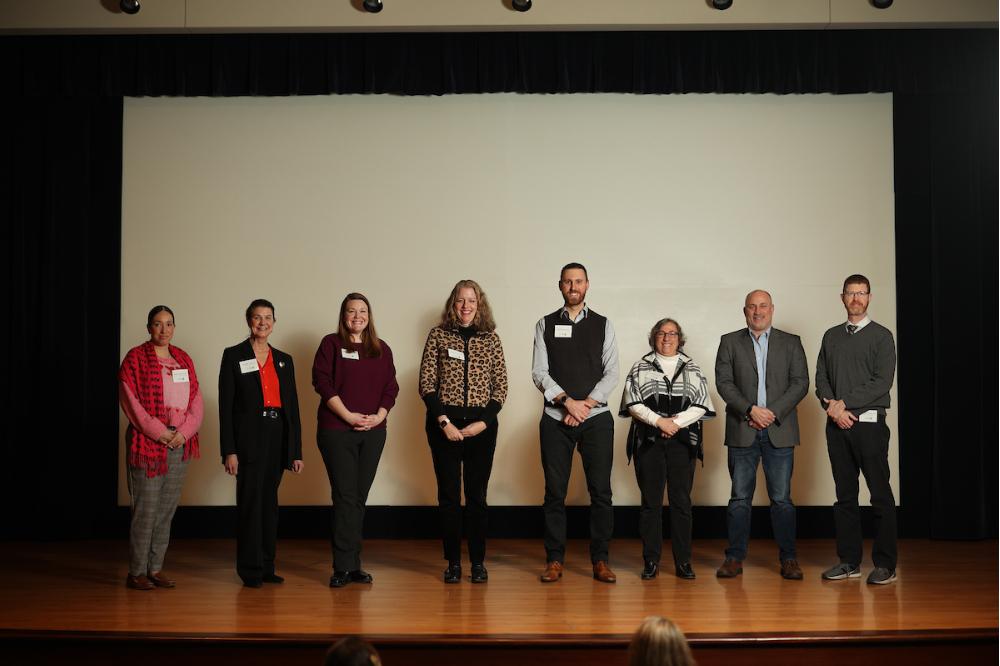 eight people lined up on stage