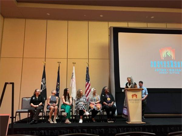 Belinda Bardwell, standing, and Dawn Rutecki, standing behind Bardwell, are on stage during an event in Battle Creek that celebrated all Native American Heritage Fund grant recipients.