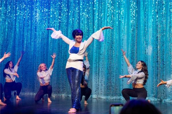 A university president joins a dance team on stage for a special surprise dance performance.