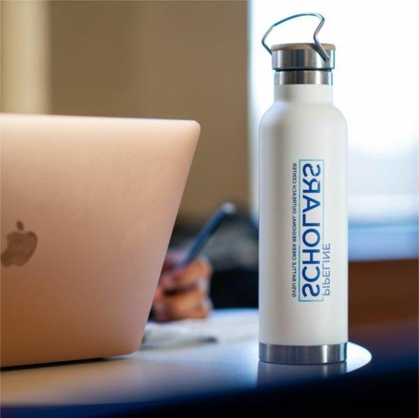 water bottle, Battle Creek Pipeline Scholars, GVSU, sits next to a MacAir laptop