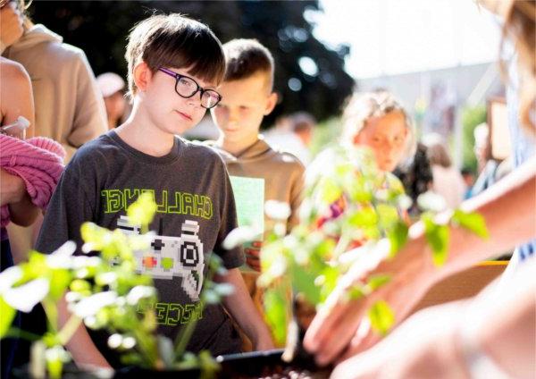 Carsen Norkus, 10, with Kent City Elementary, visits a booth during the Groundswell Stewardship Initiative student project showcase on the Pew Grand Rapids Campus May 15.