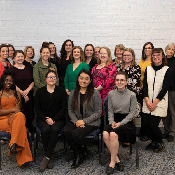 Three rows of women, front row seated, other two standing