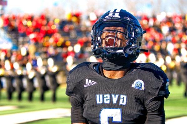  A college football player lets out a scream in front of the student section. 