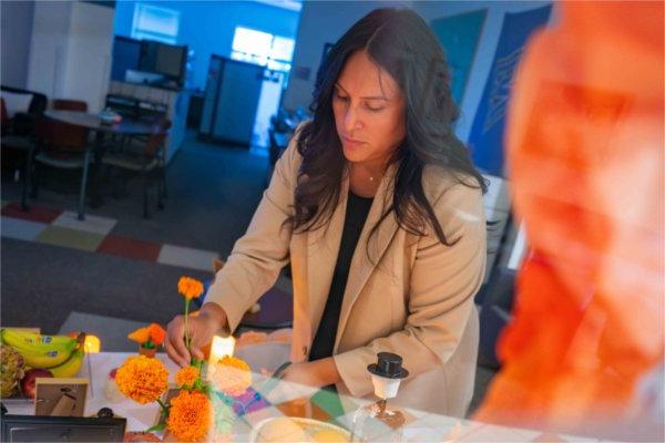   A person prepares a Day of the Dead altar.