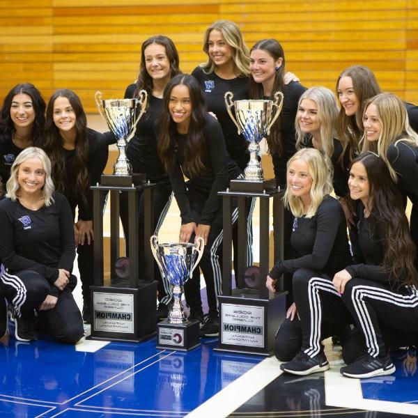 Members of Lakers Dance Team pose with national championships trophies.