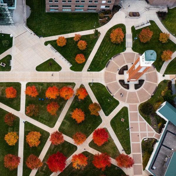 Carillon Tower and bright orange and red trees viewed from a drone above.