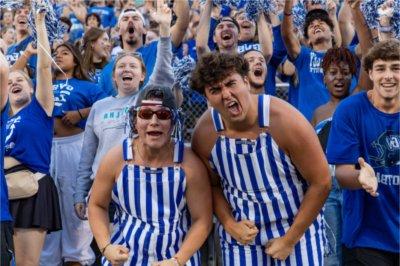 Students cheering at a GVSU football game.