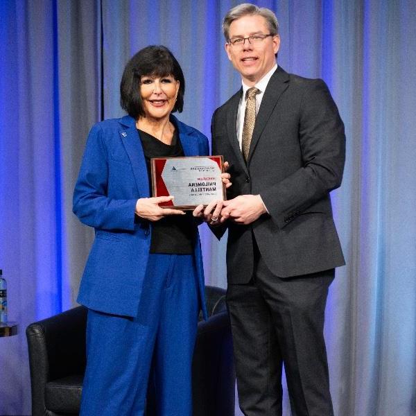 Crain's Executive Editor Mickey Ciokajlo poses while presenting GVSU President Philomena V. Mantella with a Newsmaker of the Year plaque.