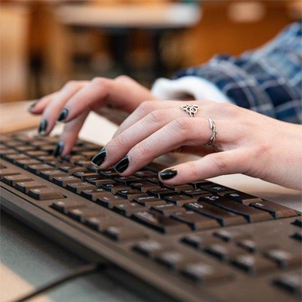 A closeup of a person typing on a keyboard.