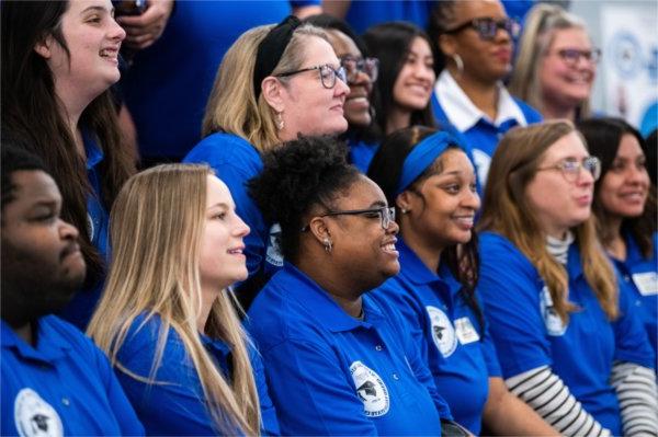 two rows of people in blue shirts