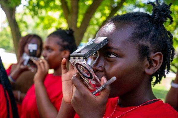 A young child puts their face into a compass during camp. 