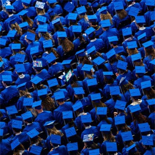 A large group of people wearing blue graduation caps.