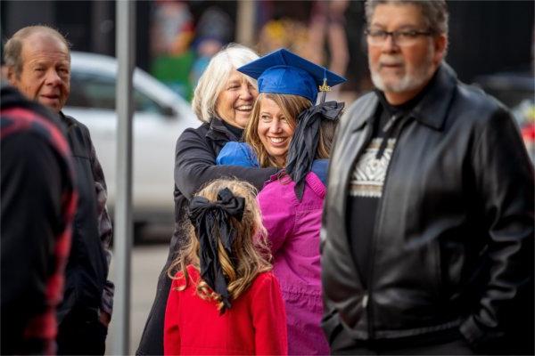 A graduate hugs her supporters.