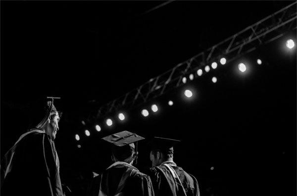 Graduates stand in line, preparing to take the stage.