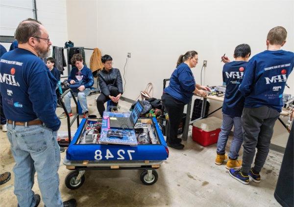 Members of the Potter&rsquo;s House robotics team, 'Tactical Hams,' work on their robot in the hallway before bringing it to the practice field.