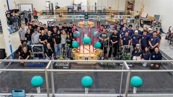 groups of students on the floor standing by their robots