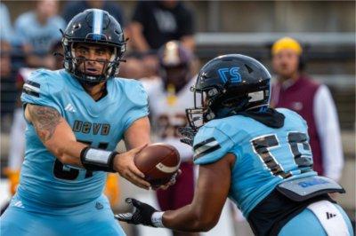 Quarterback Avery Moore hands the ball off to running back Khalil Eichelberger.