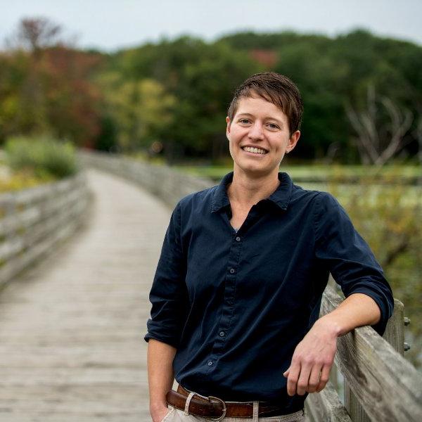 Amanda Buday stands on a boardwalk near water.