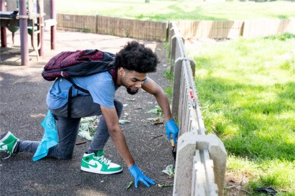 A student from University Prep Science and Math High School in Detroit pulls weeds from a playground at Belle Isle Park.