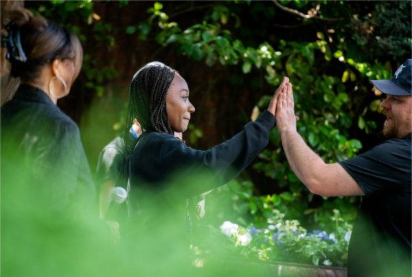  A student gives a high five to a camera man after an interview. 