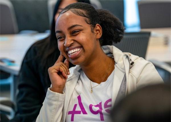 Finance and accounting major Joyeuse Murerwa smiles during a conversation with Carla Harris and President Philomena V. Mantella