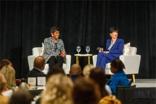 President Philomena V. Mantella and Carla Harris react to a question from the audience during an event with the Economic Club of Grand Rapids.