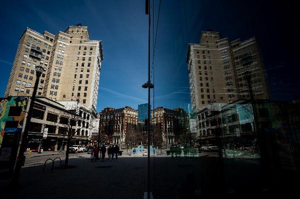  A city skyline is reflected in a glass storefront. 