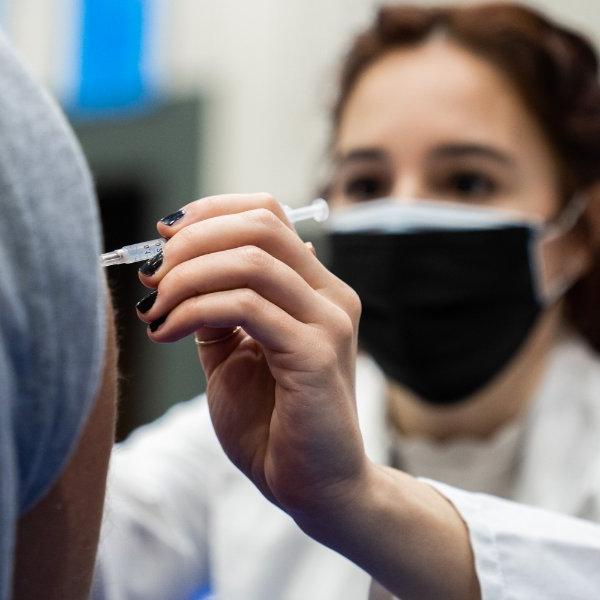 A student in the Physician Assistant Studies program gives a COVID-19 vaccination shot.