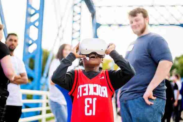 A small child uses a VR headset while smiling. 