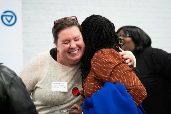  Two adults hug during an event. 