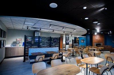 interior of Laker Club with tables and chairs and wall hiding the buffet line