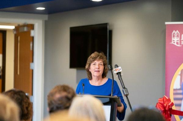 A person speaks at a podium in front of an audience.