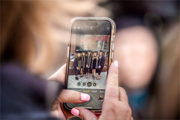  A detail photo of a cellphone picture of a group of graduates. 