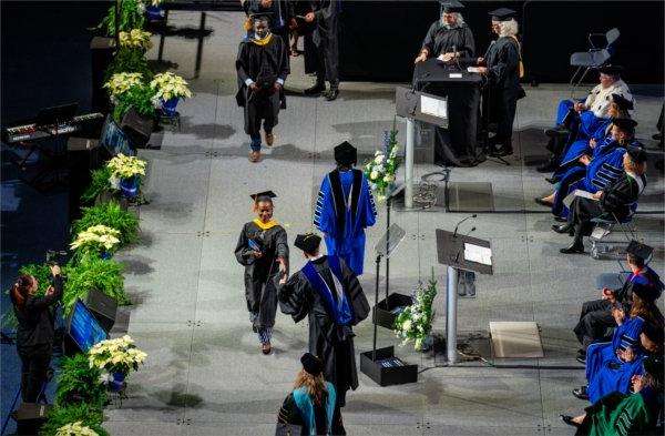  A graduate crosses the stage for their diploma. 