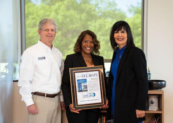 from left are President Mantella, Valerie Rhodes-Sorrelle and Greg Sanial. Valerie is holding a large plaque from Insight Into Diversity.