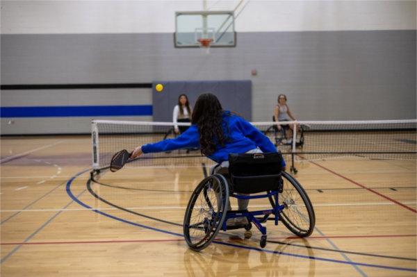 Students participate in a game of wheelchair pickleball. 