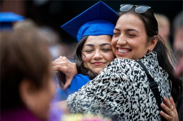 A graduate hugs their family member. 