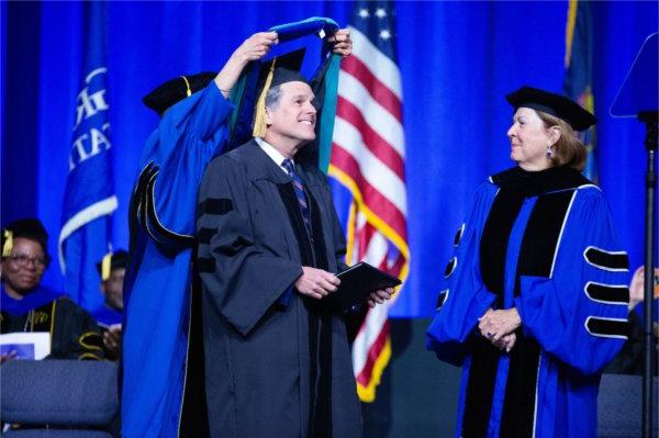  A person is hooded as they receive their honorary doctorate degree. 