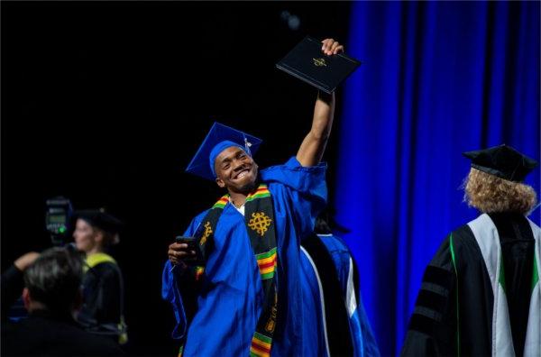   A graduate celebrates as they cross the stage.