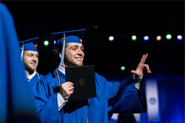   Graduates celebrate as they cross the stage during Commencement. 