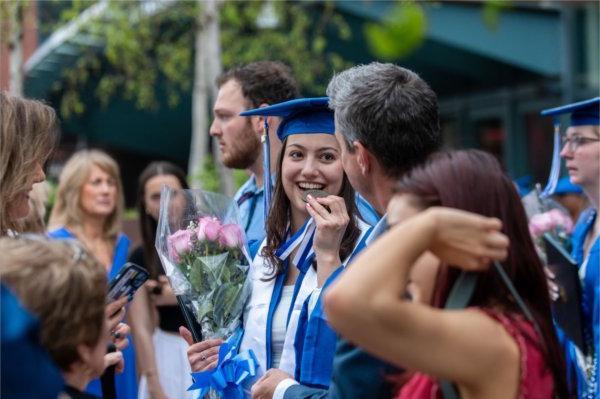  A graduate bites the medallion around their neck. 