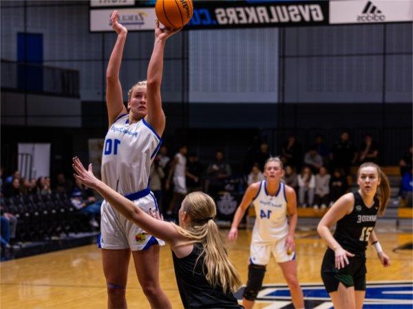 Mackenzie Bisballe takes the jump shot from the middle, after receiving the ball from her sister Rylie, who watches the play from behind her.