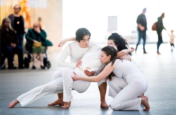  Dancers wearing white perform a modern dance routine. 