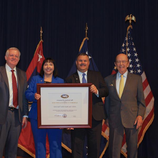 Sonja Johnson and Mark Bleckley pose for a photograph with the President's "E" Award.