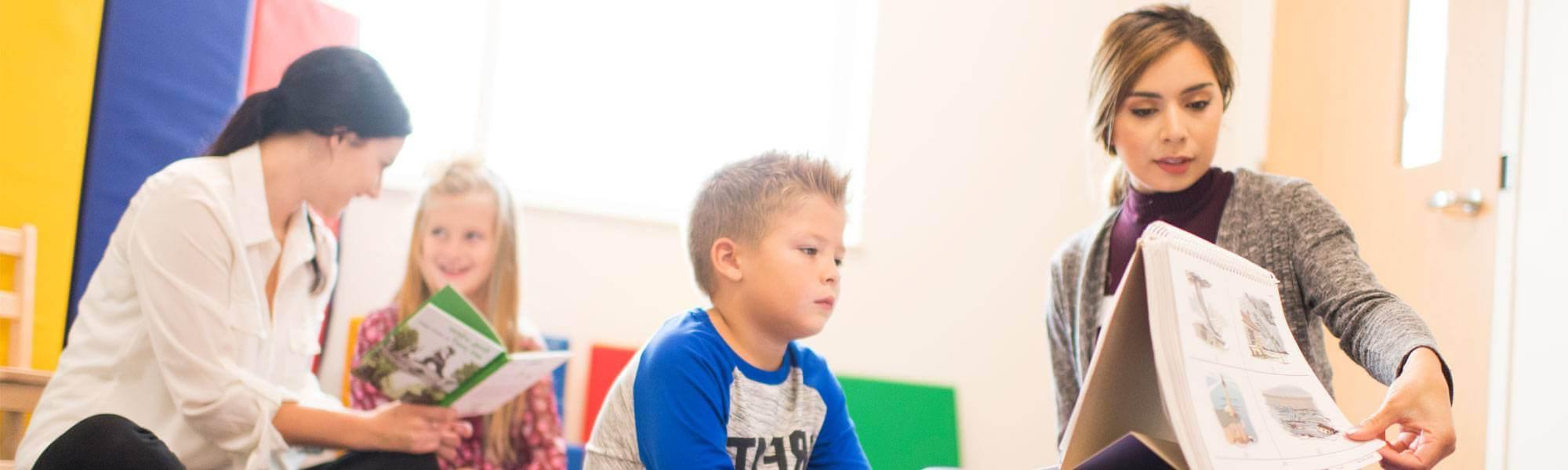 Speech pathology professional working with elementary school students.