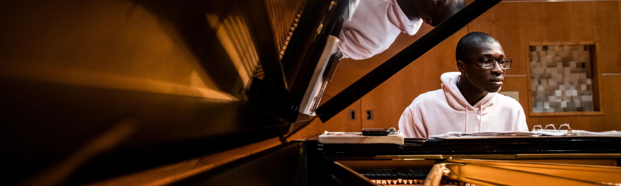 A GVSU music student plays the piano in the Louis Armstrong Theatre.